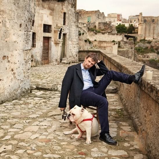 Daniele Kihlgren con il suo cane tra le case in pietra